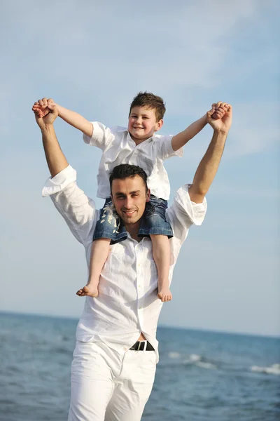 Счастливые отец и сын весело проводят время на пляже — стоковое фото