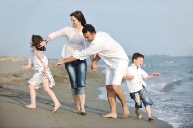 Mutlu genç aile sahilde eğleniyor.