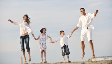Mutlu genç aile sahilde eğleniyor.