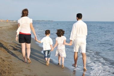 Mutlu genç aile sahilde eğleniyor.