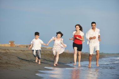 Mutlu genç aile sahilde eğleniyor.