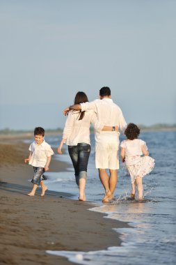 Mutlu genç aile sahilde eğleniyor.