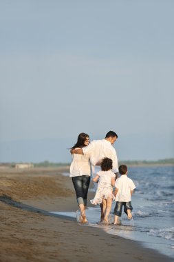 Mutlu genç aile sahilde eğleniyor.