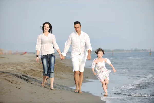 Gelukkig jong gezin veel plezier op het strand bij zonsondergang — Stockfoto