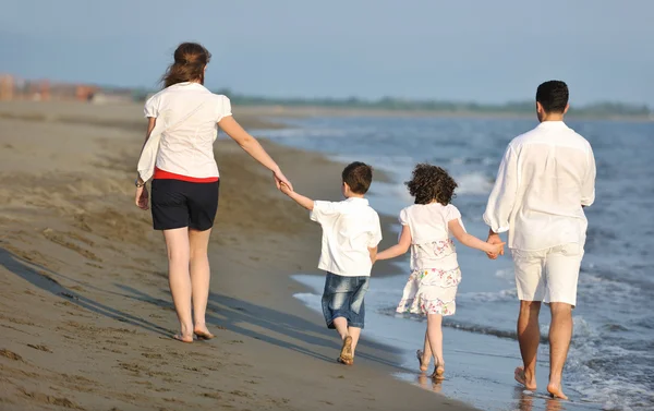 Ευτυχισμένη νεαρή οικογένεια διασκεδάστε στην παραλία το ηλιοβασίλεμα — Φωτογραφία Αρχείου