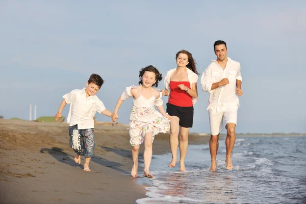 Szczęśliwa młoda rodzina baw się dobrze na plaży — Zdjęcie stockowe