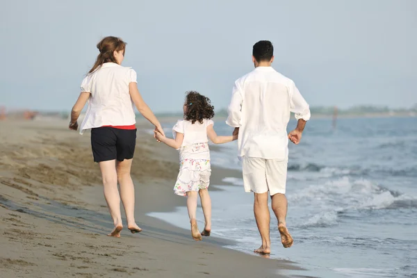 Щаслива молода сім'я розважається на пляжі — стокове фото