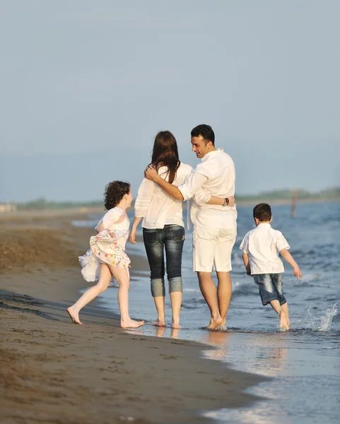 Onnellinen nuori perhe pitää hauskaa rannalla — kuvapankkivalokuva