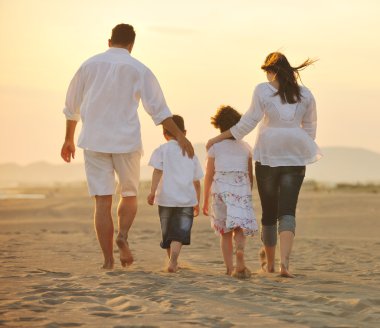 Happy young family have fun on beach at sunset clipart