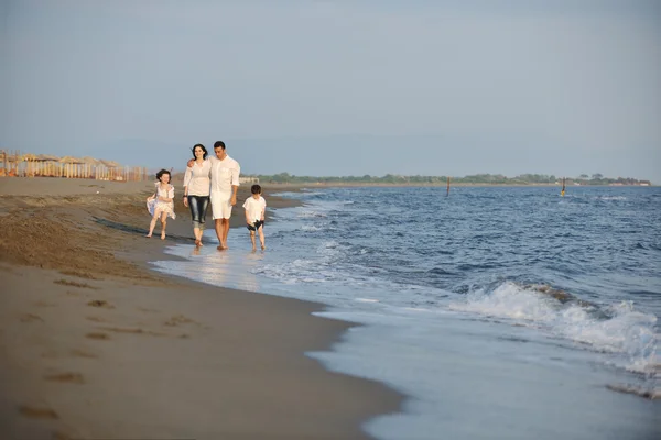 खुश युवा परिवार सूर्यास्त पर समुद्र तट पर मज़ा है — स्टॉक फ़ोटो, इमेज