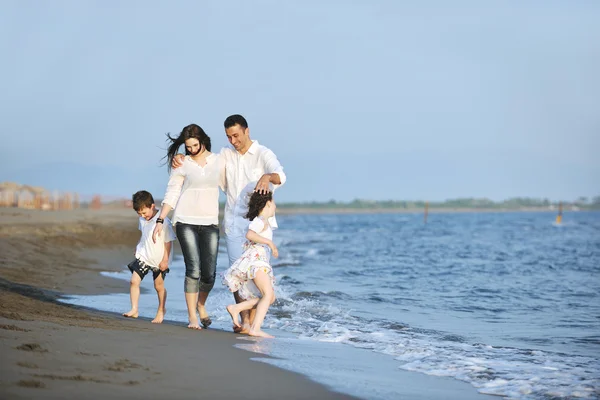 Mutlu genç aile gün batımında sahilde eğleniyor. — Stok fotoğraf