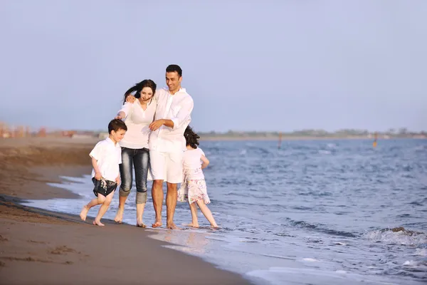 Heureux jeune famille amusez-vous sur la plage au coucher du soleil — Photo