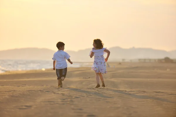 Gelukkig jong gezin veel plezier op het strand bij zonsondergang — Stockfoto