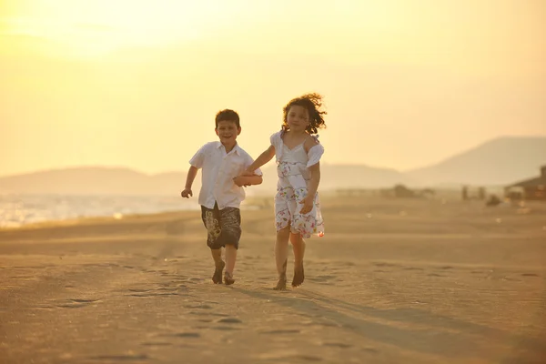 Ευτυχισμένη νεαρή οικογένεια διασκεδάστε στην παραλία το ηλιοβασίλεμα — Φωτογραφία Αρχείου