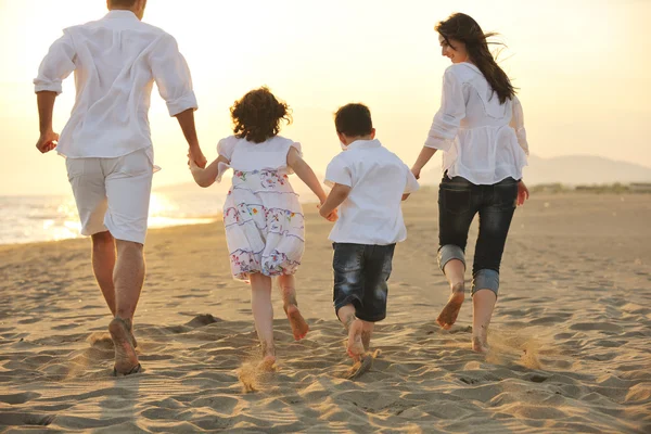 Happy young family have fun on beach at sunset — Stock Photo, Image