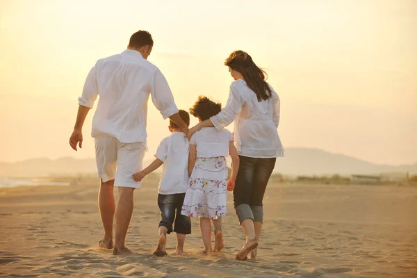 Felice giovane famiglia divertirsi sulla spiaggia al tramonto — Foto Stock