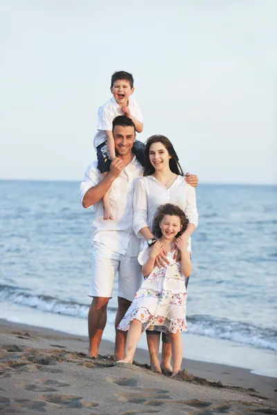 幸せな若い家族はビーチで楽しんでいます — ストック写真