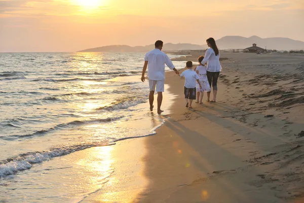 Heureux jeune famille amusez-vous sur la plage au coucher du soleil — Photo