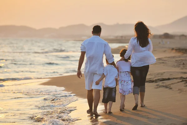 Feliz familia joven divertirse en la playa al atardecer —  Fotos de Stock