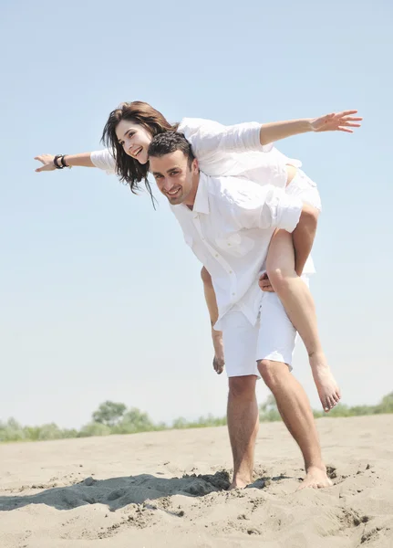 Heureux jeune couple avoir du plaisir sur la plage — Photo