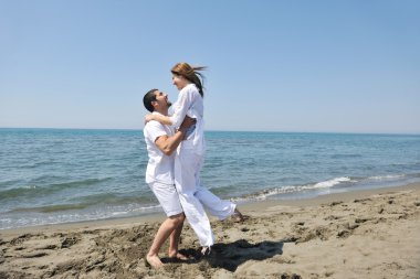 Happy young couple have fun on beach clipart