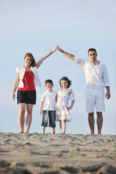 Familjen på stranden visar hem tecken — Stockfoto