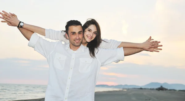 Onnellinen nuori pari pitää hauskaa rannalla — kuvapankkivalokuva