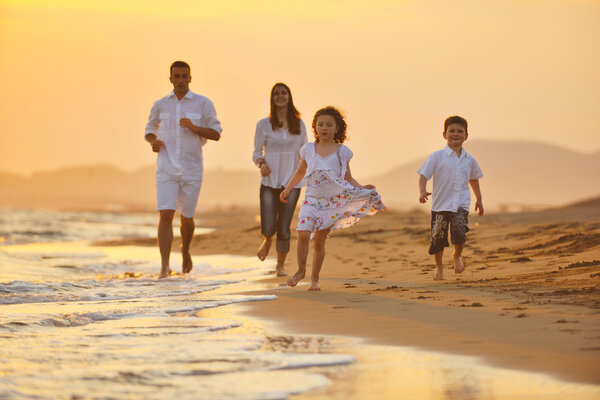 Happy young family have fun on beach at sunset