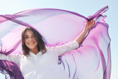 Beautiful young woman on beach with scarf clipart