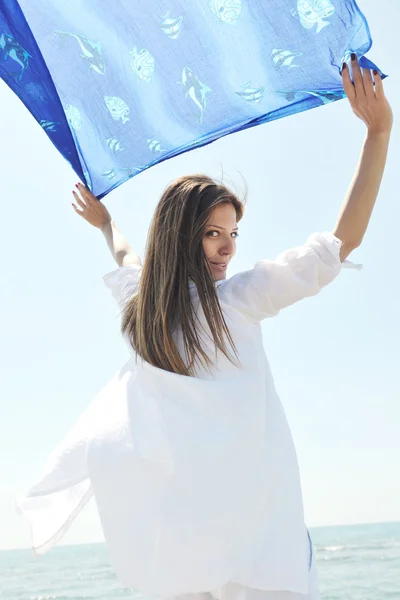 Красивая молодая женщина на пляже с шарфом — стоковое фото