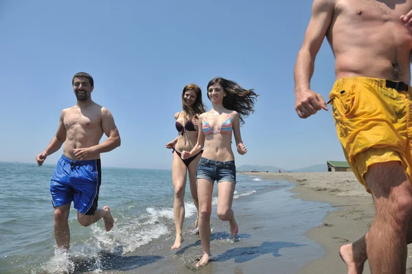 Gelukkig groep hebben pret en lopende op strand — Stockfoto