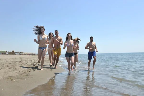 Счастливая группа веселится и бегает по пляжу — стоковое фото