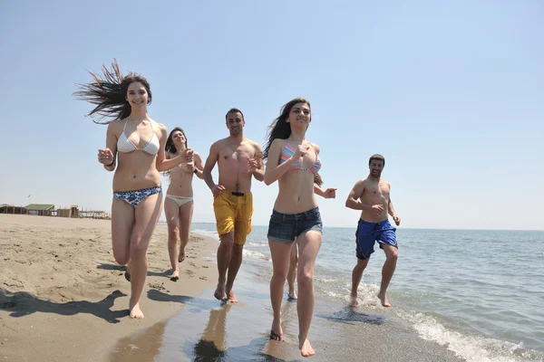 Gelukkig groep hebben pret en lopende op strand — Stockfoto
