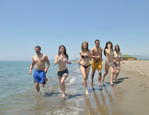 Heureux groupe avoir amusant et courir sur la plage — Photo