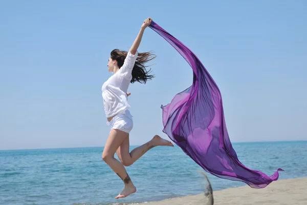 Bela jovem mulher na praia com cachecol — Fotografia de Stock