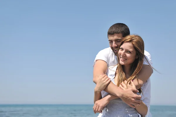 Счастливая молодая пара веселится на пляже — стоковое фото