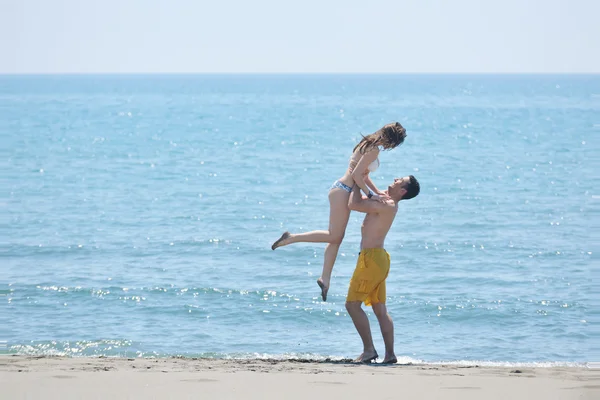 Счастливая молодая пара проводит романтическое время на пляже — стоковое фото