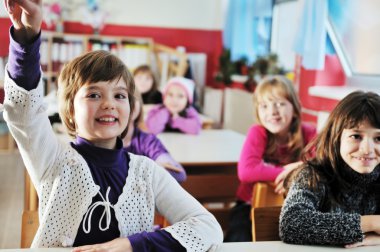 Happy kids with teacher in school classroom clipart