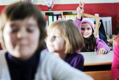 Happy kids with teacher in school classroom clipart