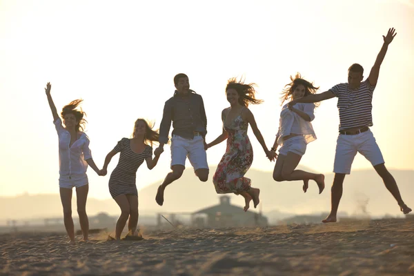 Groep van gelukkige jonge in plezier hebben op strand — Stockfoto