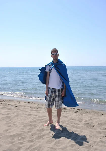 Srandovní superhrdina stojící na pláži — Stock fotografie