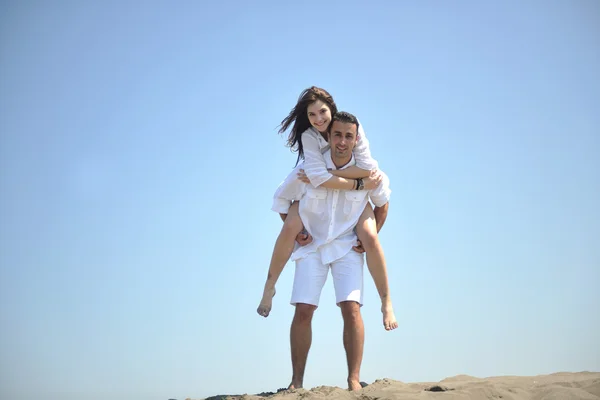 幸せな若いカップルはビーチで楽しんでいます — ストック写真