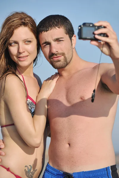 Feliz jovem casal apaixonado tirar fotos na praia — Fotografia de Stock