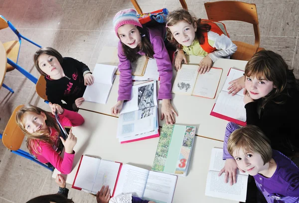 Crianças felizes com professor na sala de aula da escola — Fotografia de Stock