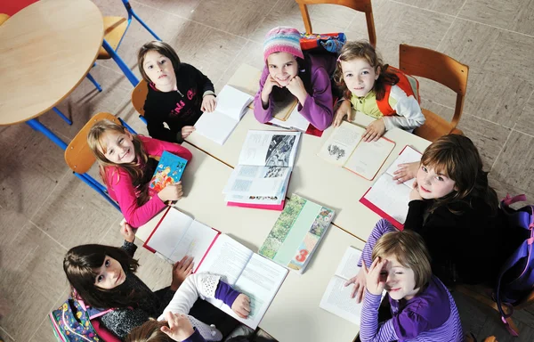 Glada barn med lärare i skola klassrum — Stockfoto