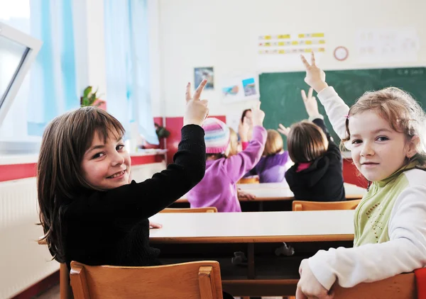 Счастливые дети с учителем в школьном классе — стоковое фото