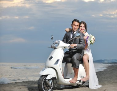 Just married couple on the beach ride white scooter clipart