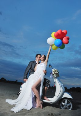 Just married couple on the beach ride white scooter clipart