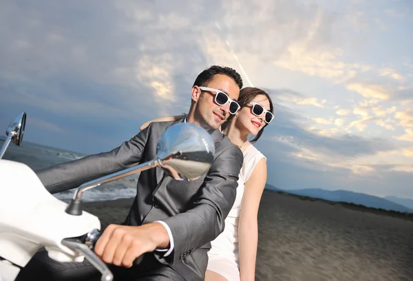Pareja recién casada en el paseo por la playa scooter blanco — Foto de Stock