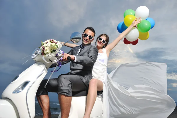 Kumsalda beyaz scooter süren evli bir çift. — Stok fotoğraf